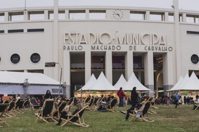 Em frente ao histórico estádio Pacaembu está a estrutura dA Feira do Livro, com cadeiras e tendas dispostas pela Praça Charles Miller.