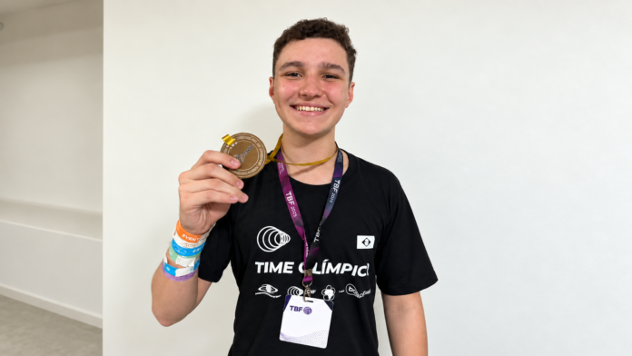 O estudante Arthur Alencar Spuri exibindo uma medalha de ouro durante uma premiação na China.